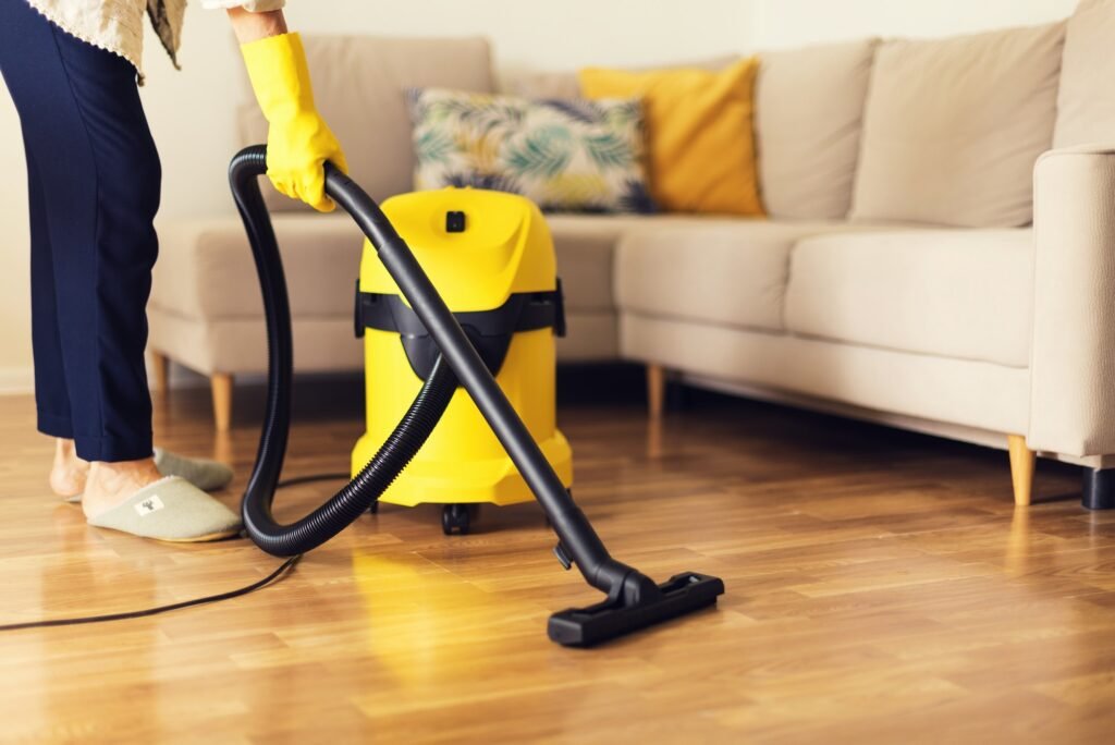 woman cleaning sofa with yellow vacuum cleaner copy space cleaning service concept